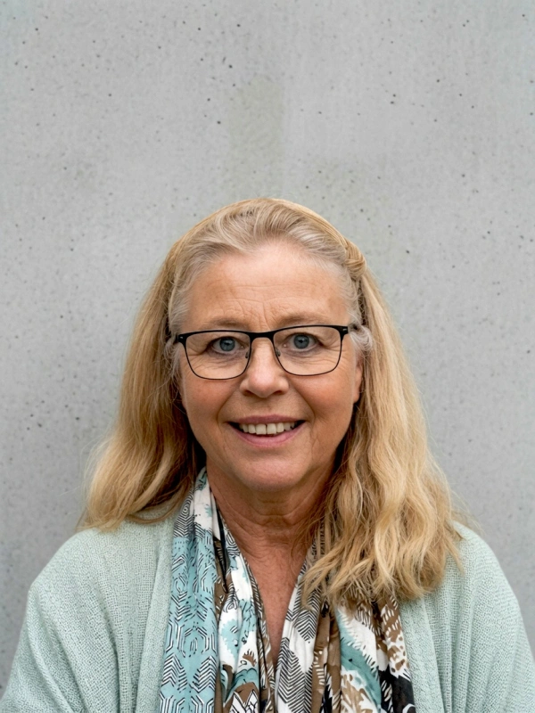 Porträtt av Milada Wurm med glasögon och ljust hår framför en ljusgrå vägg.